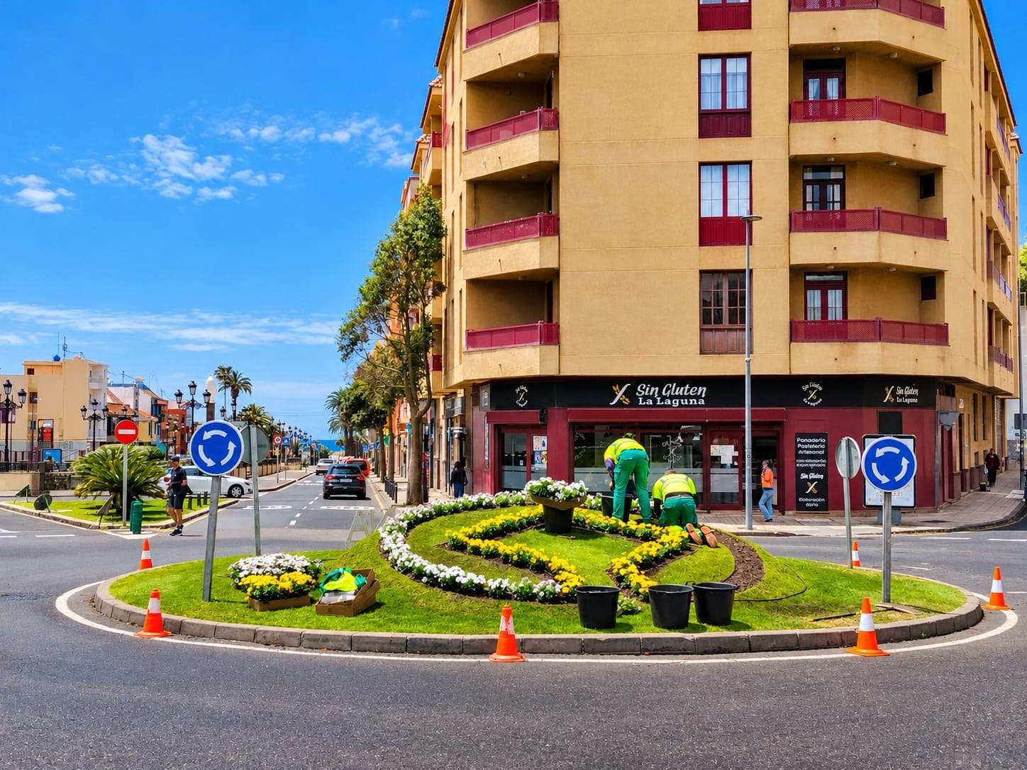 Dos jardineros plantando flores en una rotonda de La Laguna.